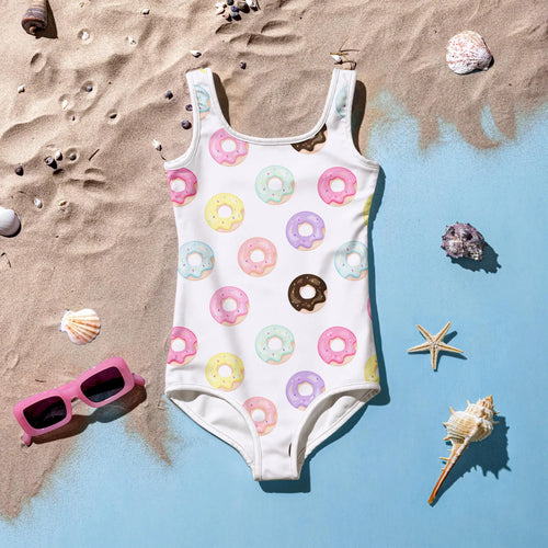 A white one-piece girls swimsuit with colorful pastel donut prints in pink yellow mint green and purple