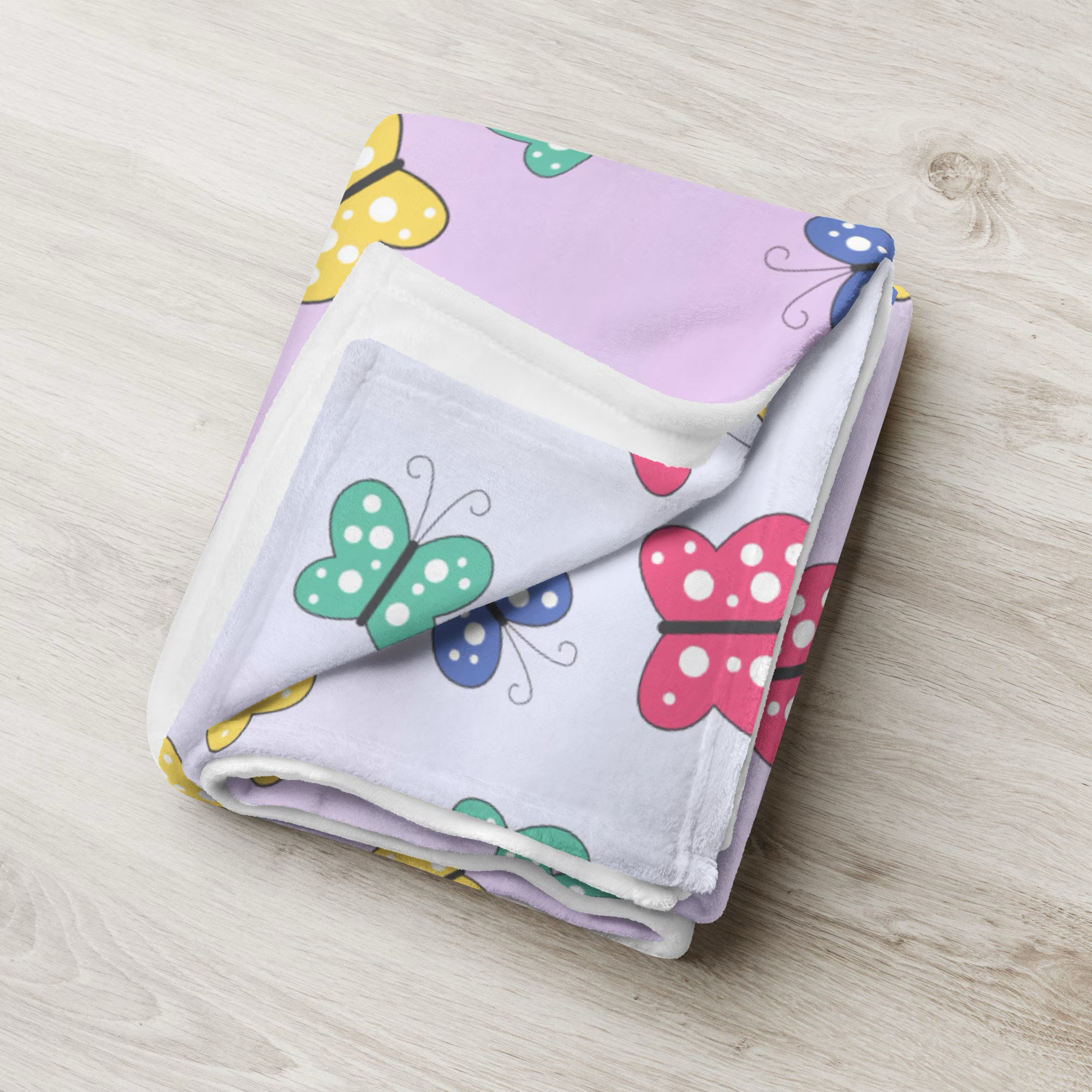 A soft lavender girls colorful butterflies blanket with playful green pink and yellow cartoon butterfly pattern