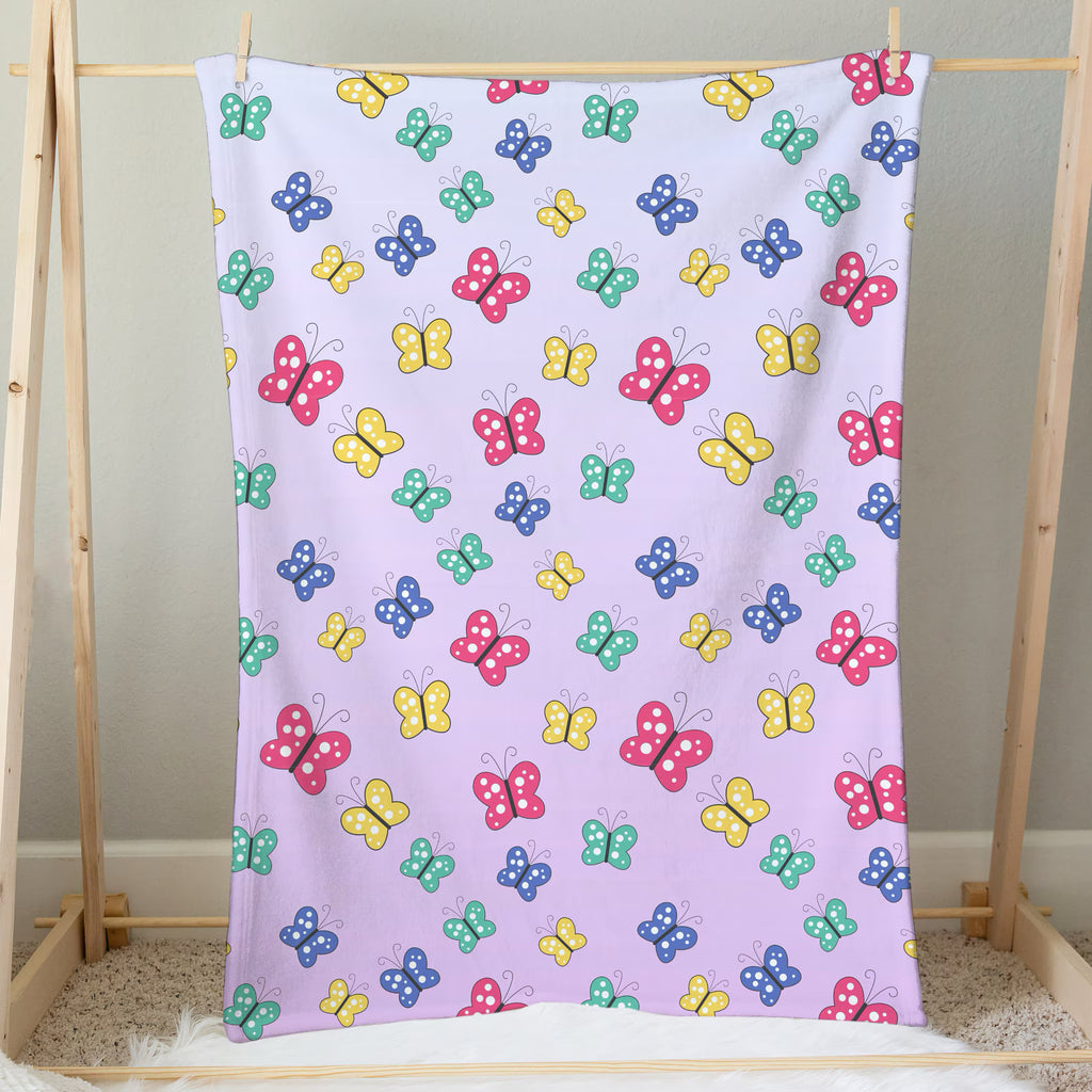 A soft lavender girls colorful butterflies blanket featuring a playful pattern of pink yellow blue and green cartoon butterflies