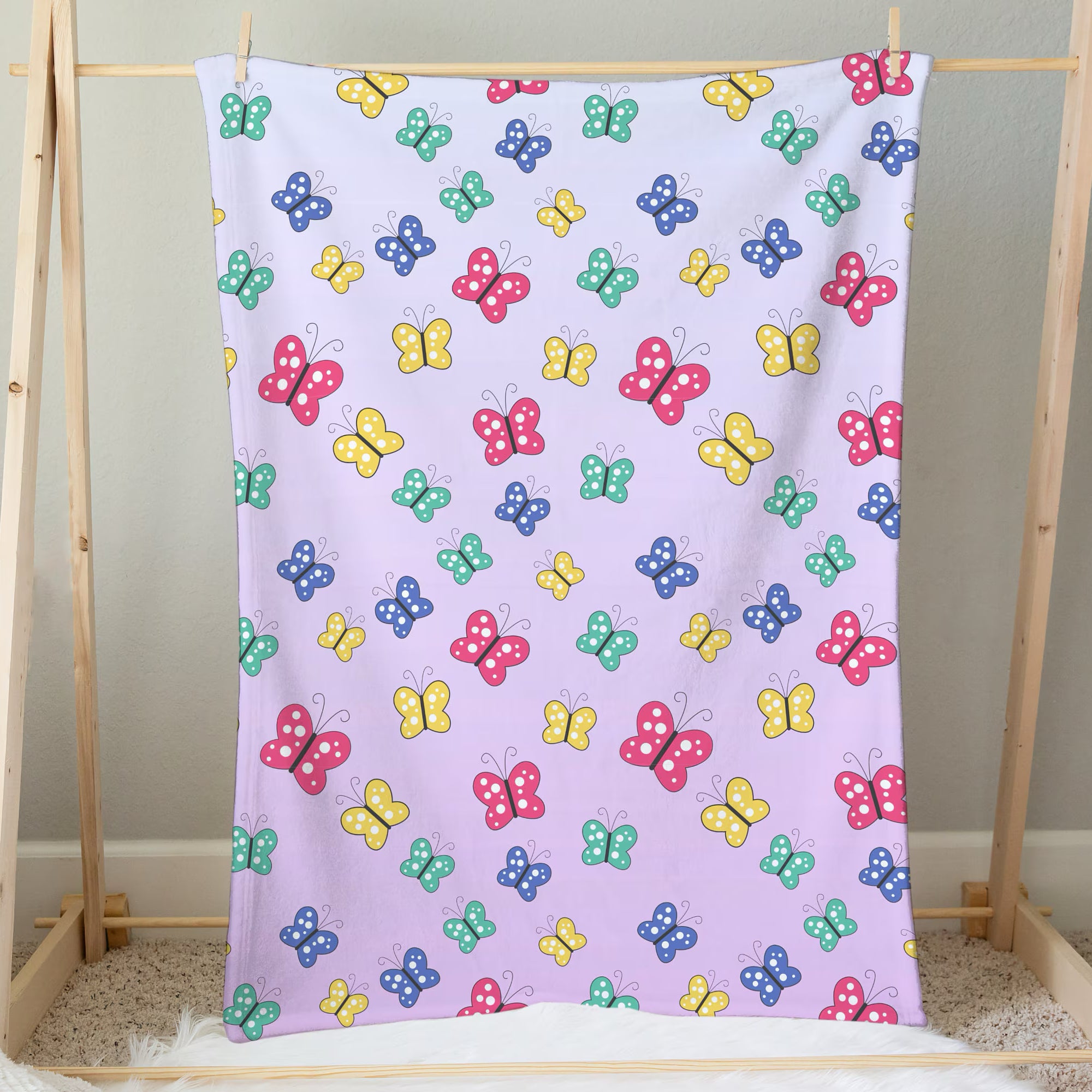 A soft lavender girls colorful butterflies blanket featuring a playful pattern of pink yellow blue and green cartoon butterflies