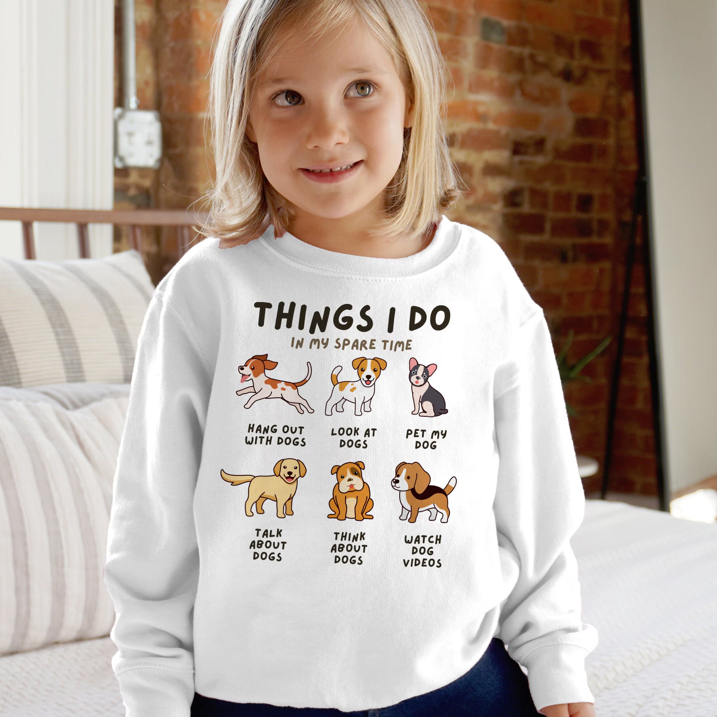 Child wearing a white sweatshirt with dog-themed graphics and text.