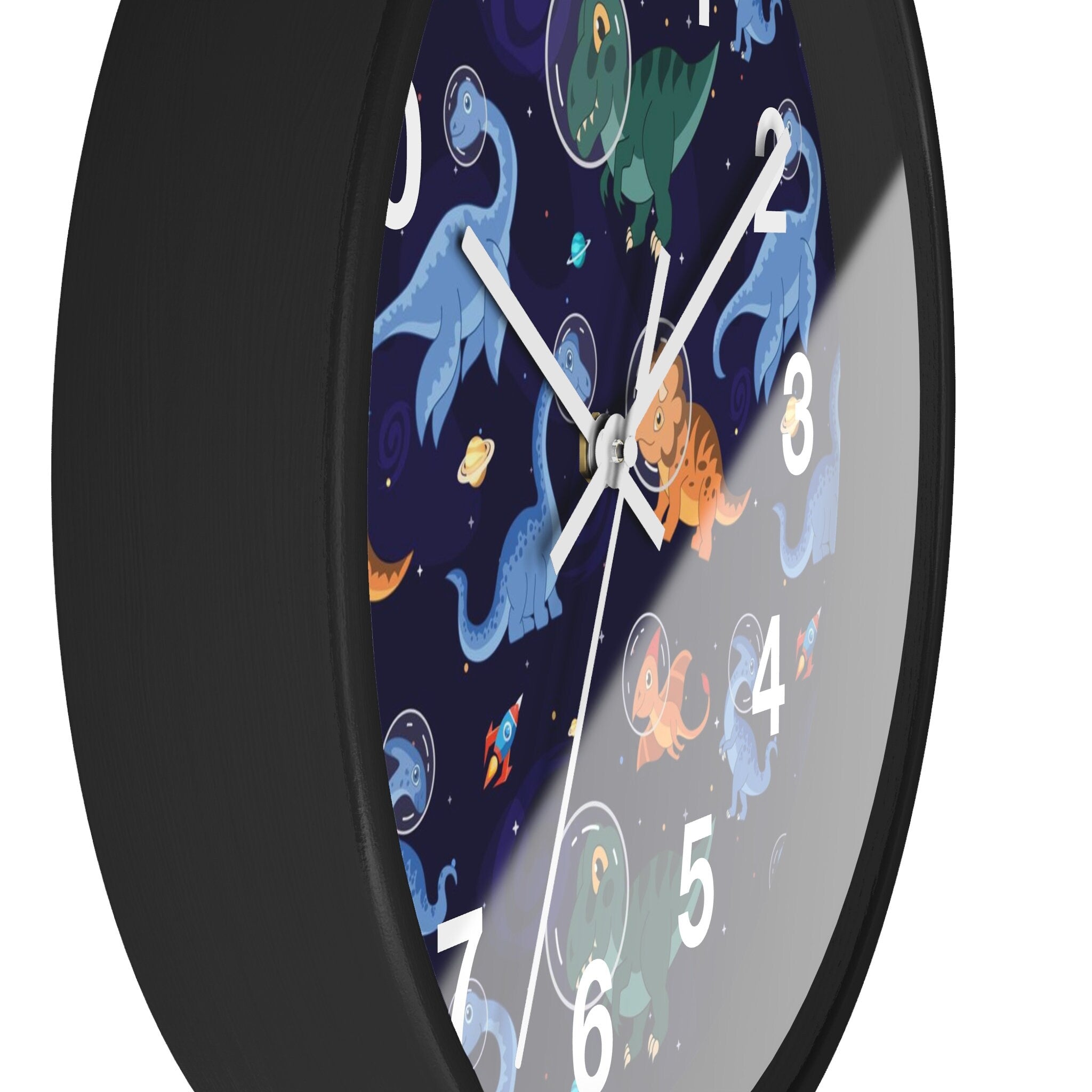 Black-framed silent wood wall clock with vibrant space-themed face featuring cartoon dinosaurs in astronaut suits