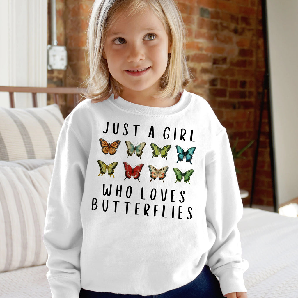 White long-sleeved girls sweatshirt with black text and colorful butterfly graphics made of soft fabric