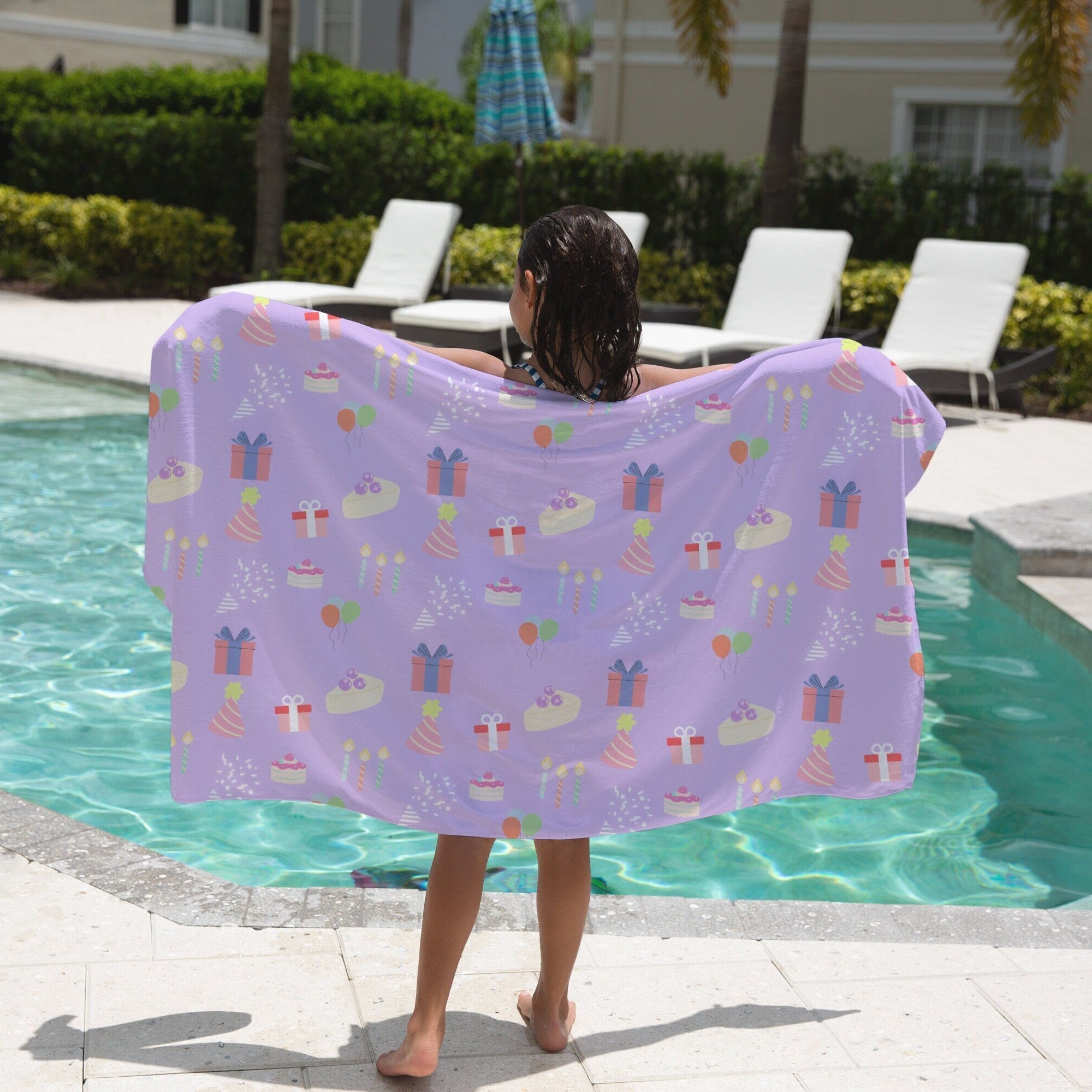 Girls birthday themed towel in lavender with playful pastel birthday cakes gift wraps party hats and balloons pattern