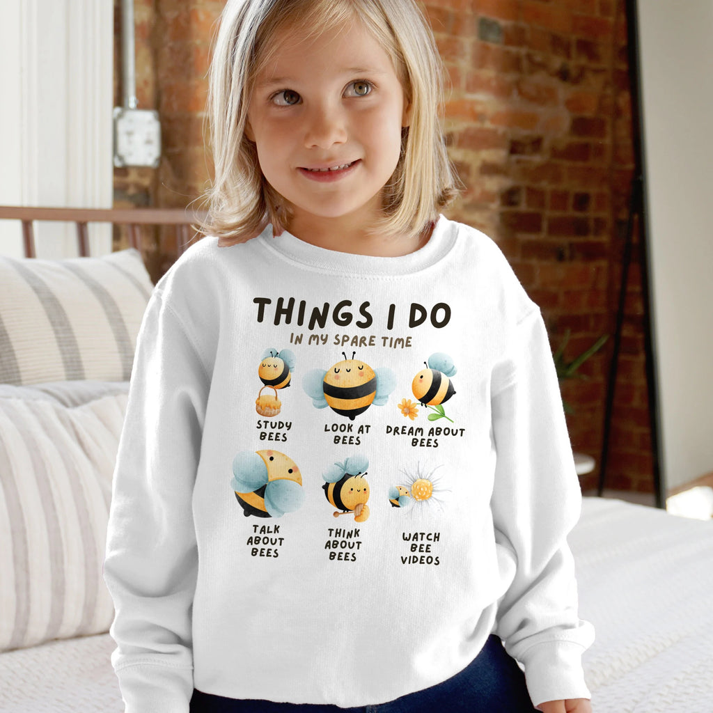 Kids white long-sleeved cotton sweatshirt with playful bee graphic and text things i do in my spare time