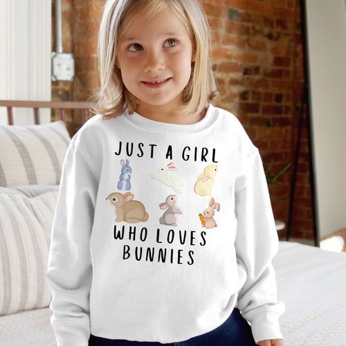 White long-sleeved girls sweatshirt with playful just a girl who loves bunnies graphic and colorful cartoon bunnies