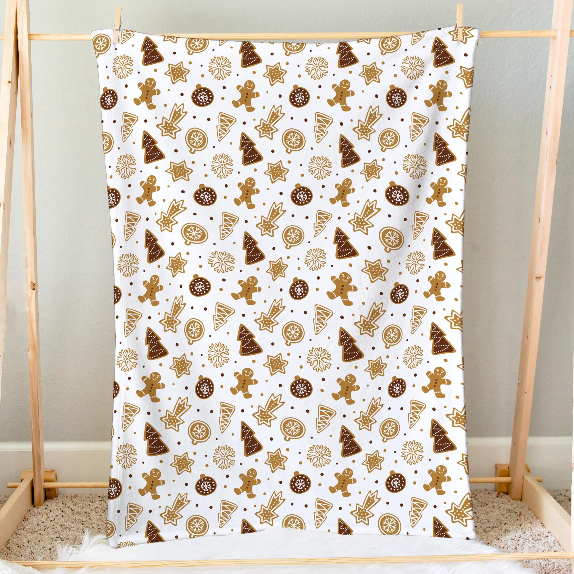 A festive white kids Christmas blanket with brown and gold gingerbread men trees stars ornaments and snowflakes pattern