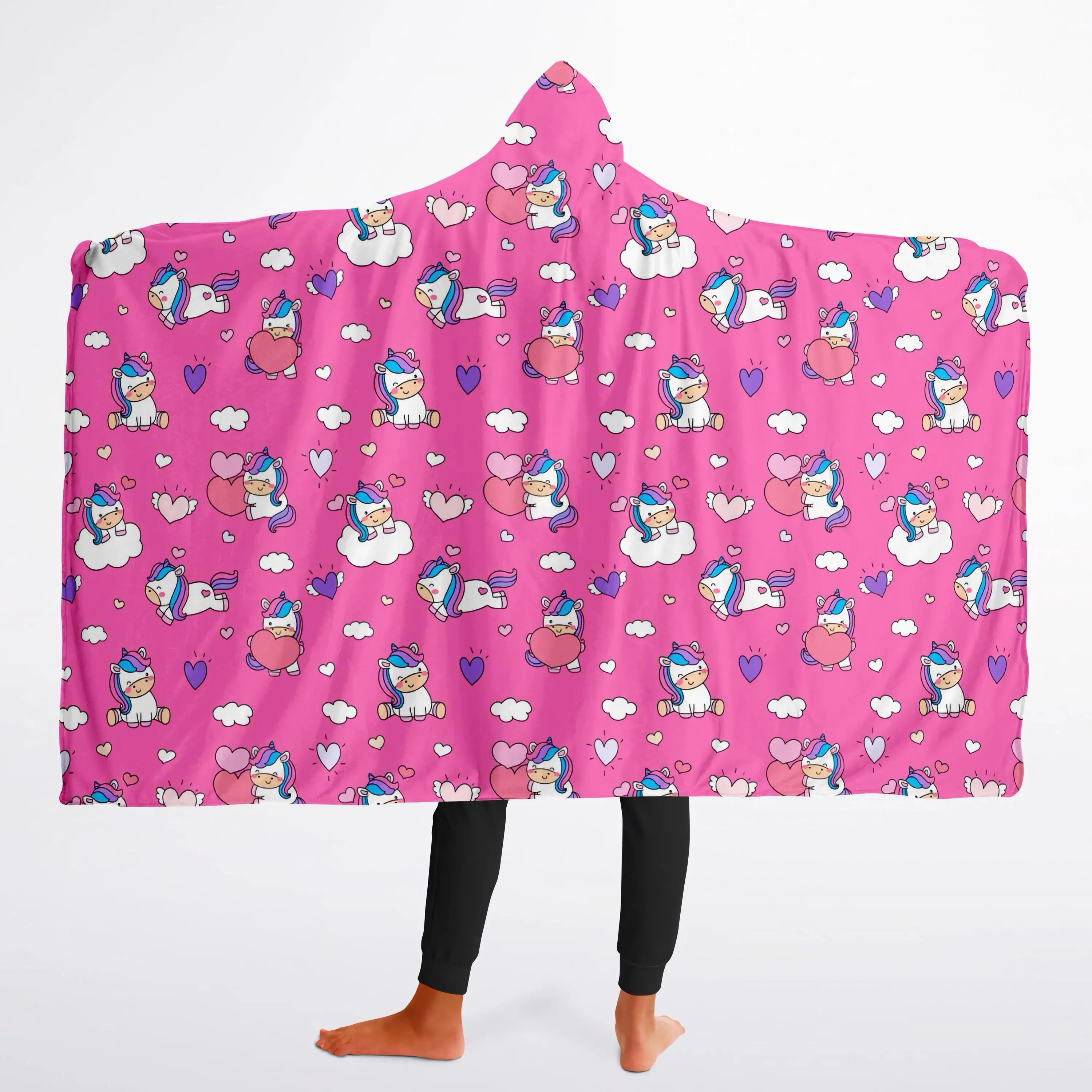 A vibrant pink girls hooded wearable blanket with cartoon unicorns hearts and clouds pattern for cozy wear