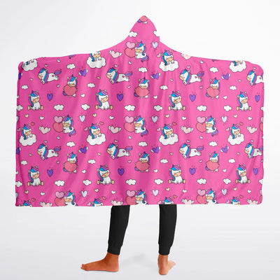 A vibrant pink girls hooded wearable blanket with cartoon unicorns hearts and clouds pattern for cozy wear