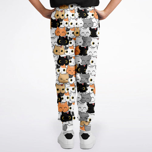 Girls cat face jogger pants in white with a playful cartoon cat pattern in black orange gray and white