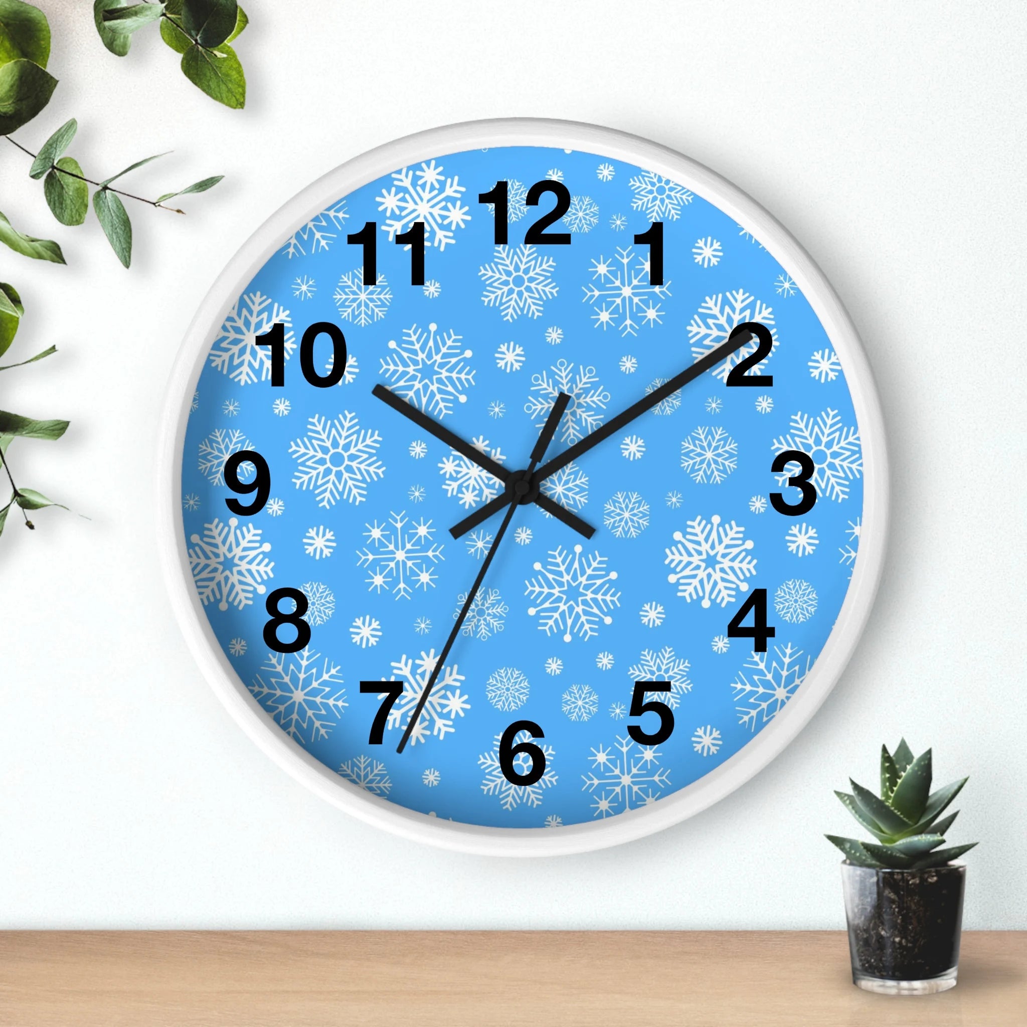Snowflakes silent wood wall clock with light blue face white snowflake patterns black numerals and white border