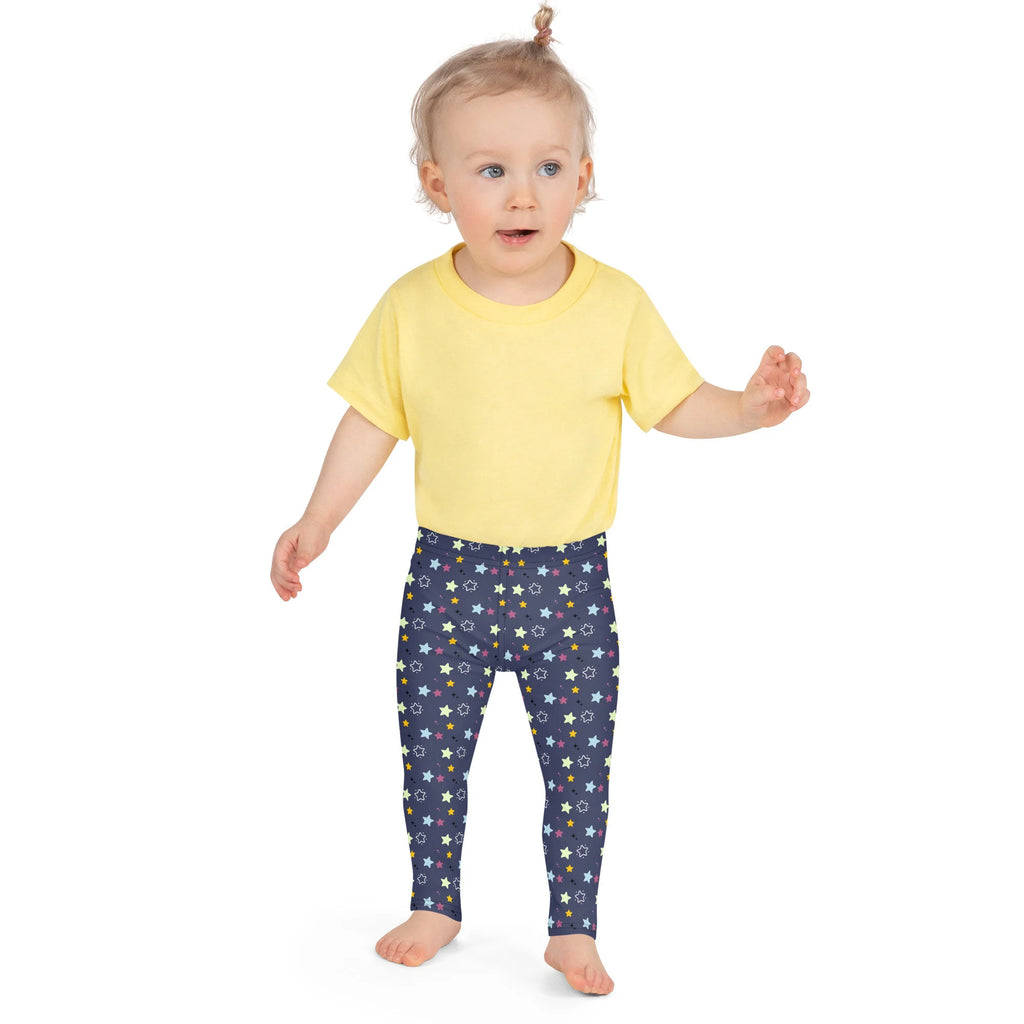 A child wearing kids night stars buttery soft leggings in navy blue with multicolored star patterns and a yellow t-shirt