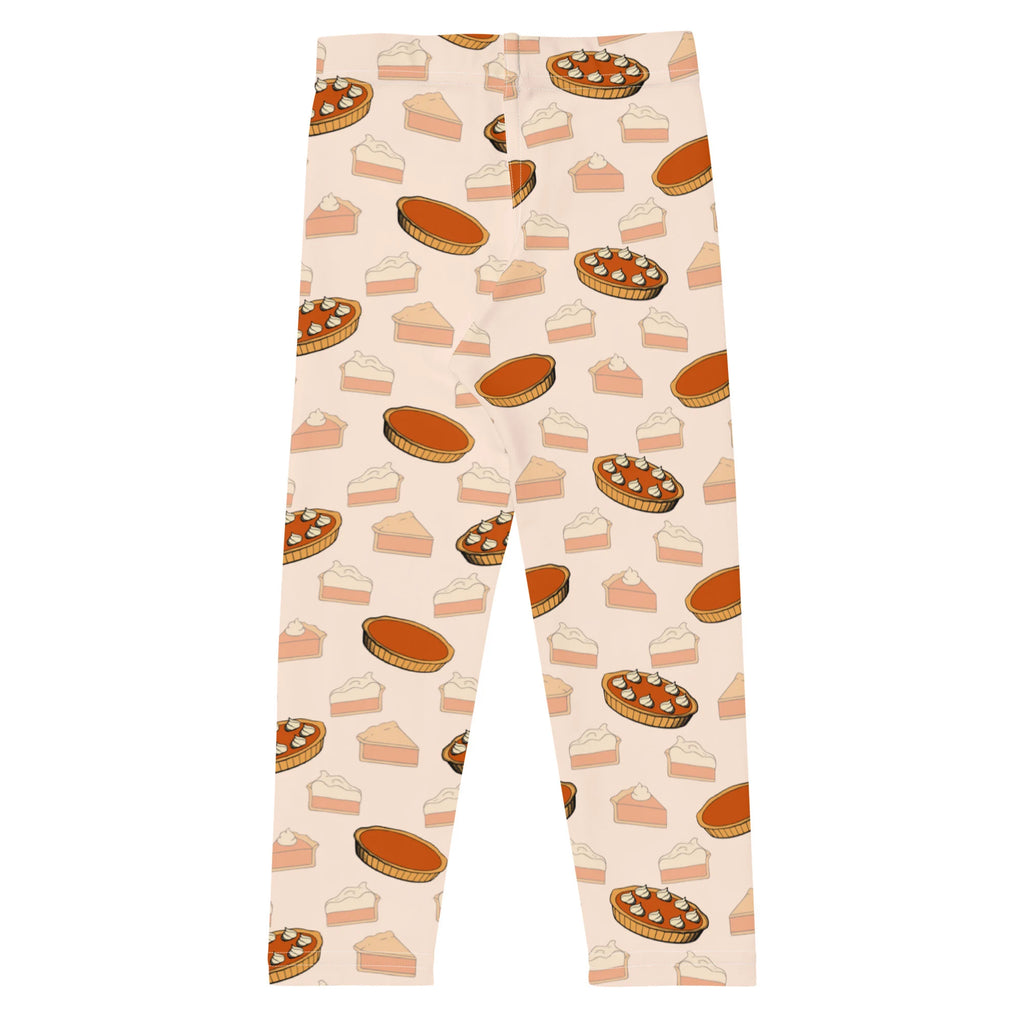 Kids pumpkin pie leggings in cream featuring playful illustrated pumpkin pies and slices in warm orange brown and beige tones