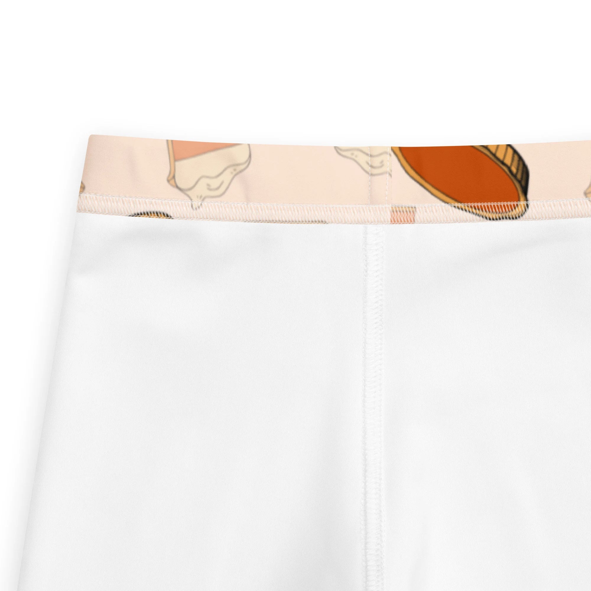 Kids pumpkin pie leggings in white high-waisted pants with a beige waistband featuring orange and brown food illustrations