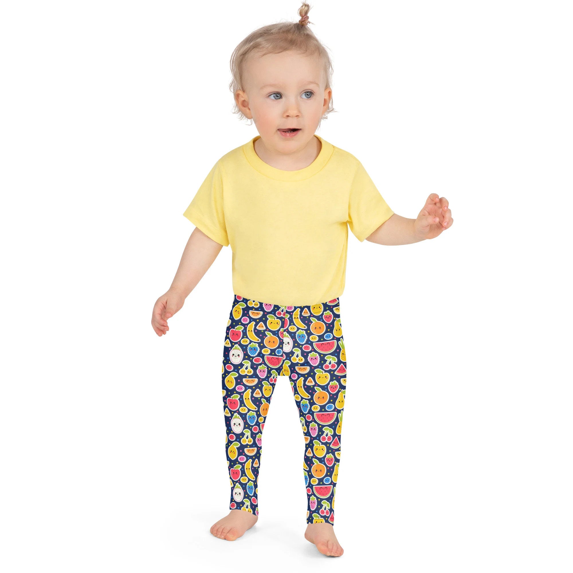 Toddler wearing a bright yellow short-sleeved t-shirt paired with girls emoji fruit buttery soft leggings