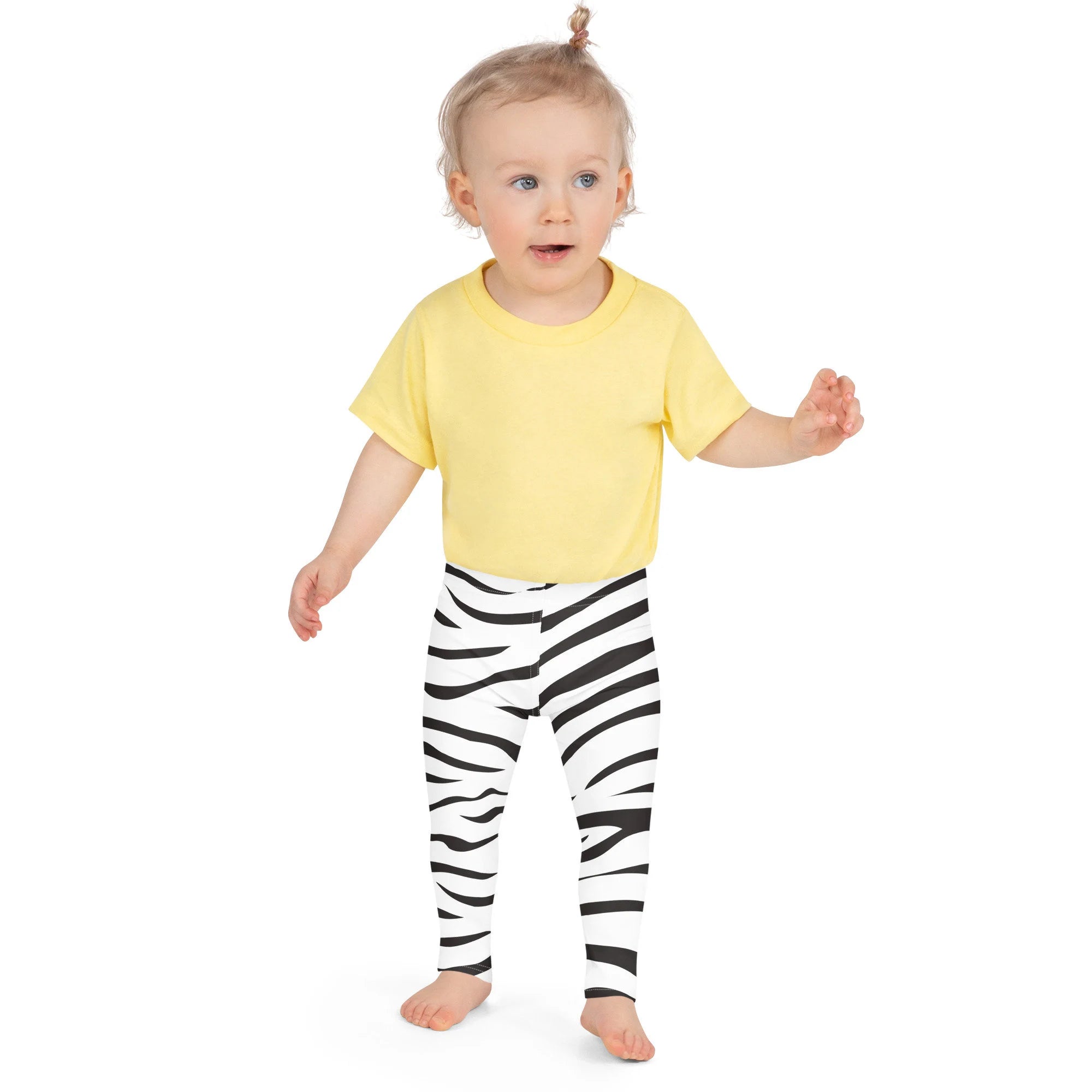 Yellow short-sleeved t-shirt paired with buttery soft black and white kids striped zebra leggings on front side
