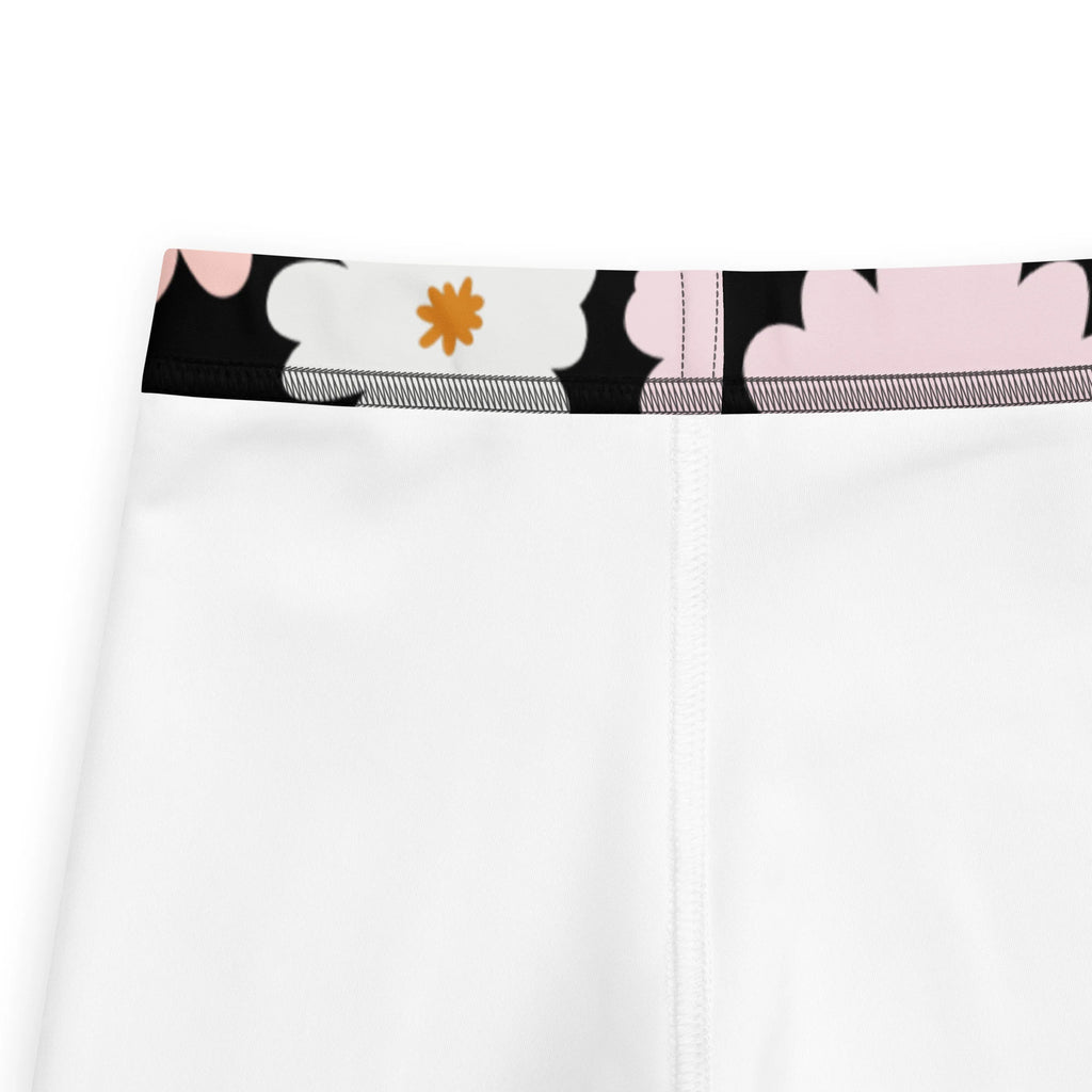 Girls flower buttery soft white leggings with black waistband and playful pink and orange floral pattern