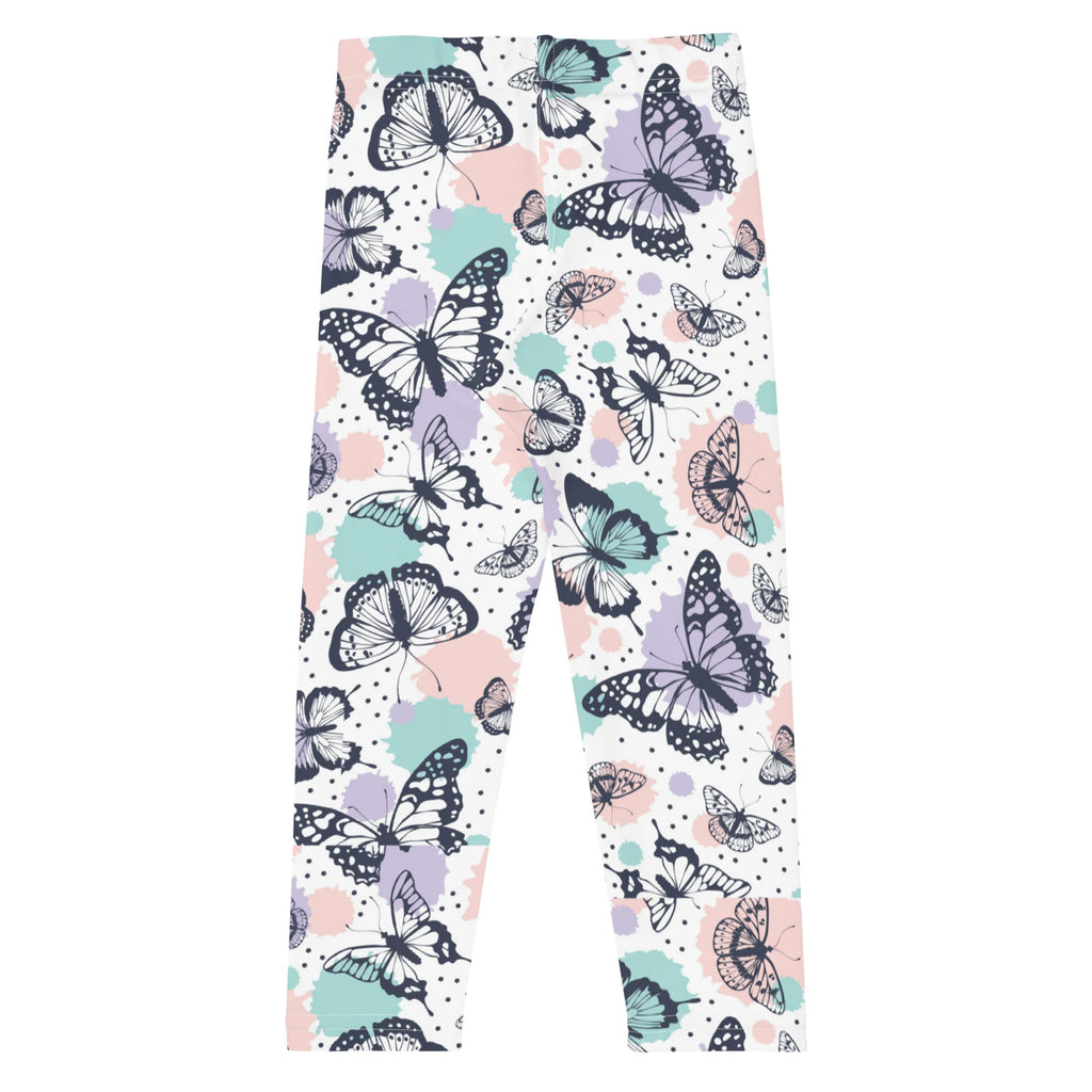 Girls butterfly buttery soft white leggings with black and teal butterfly pattern over pastel splashes