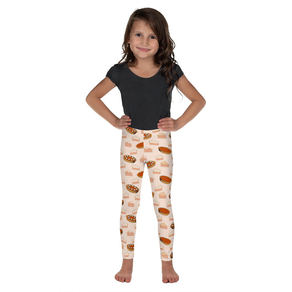 A child wearing light-colored kids pumpkin pie leggings with a warm golden-brown pie slice pattern
