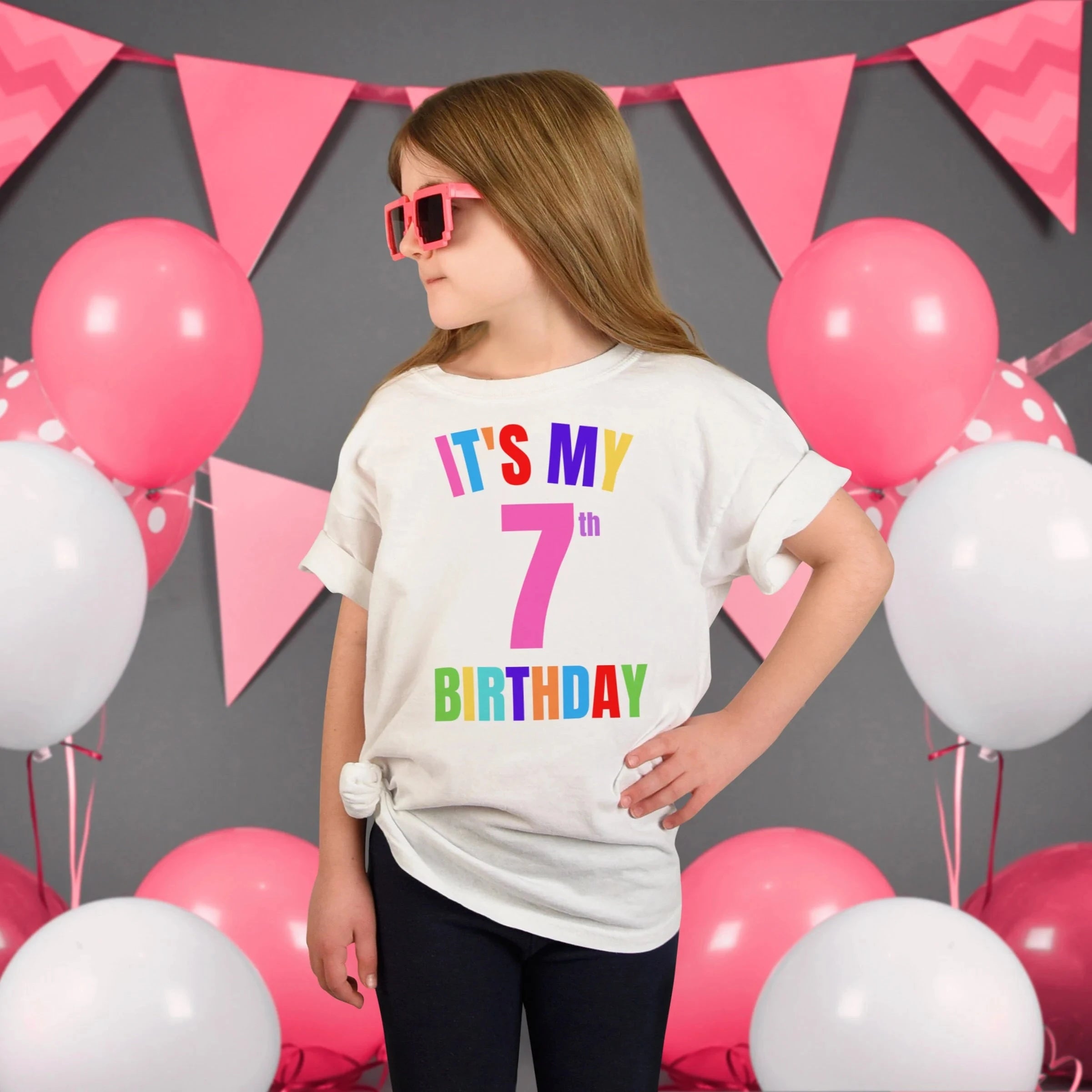 White cotton kids custom age t-shirt with colorful its my 7th birthday rainbow graphic and large pink number seven