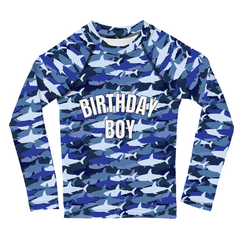 Blue and white shark camouflage long sleeve rash guard with birthday boy printed in bold white letters on chest