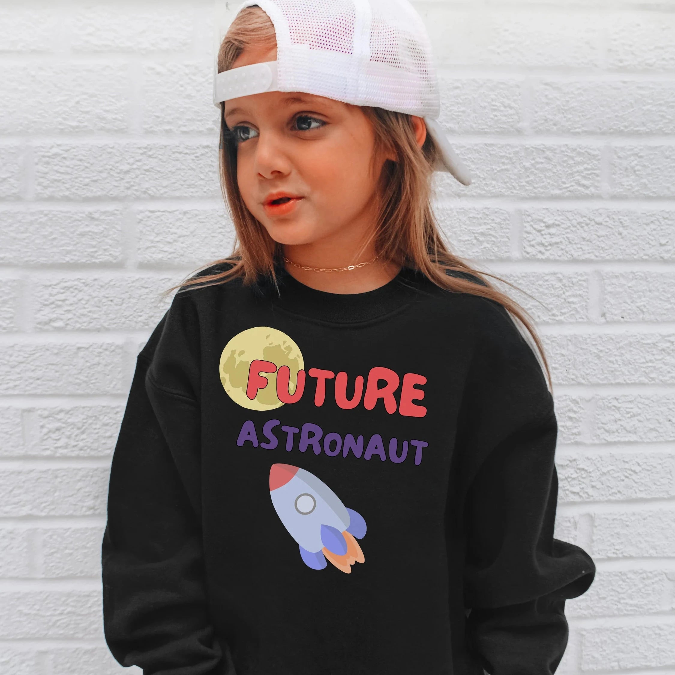 Black long-sleeved kids sweatshirt with future astronaut graphic featuring yellow moon red and purple text and rocket