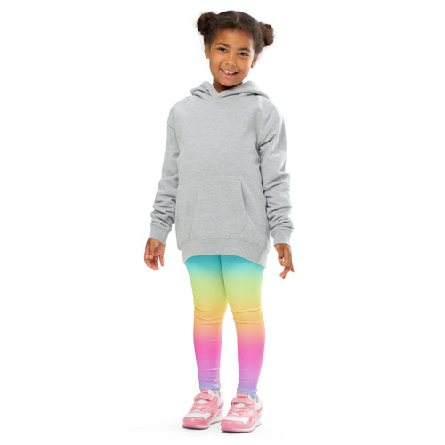 A child wearing girls bright rainbow buttery soft leggings with a light gray hooded sweatshirt and pink sneakers
