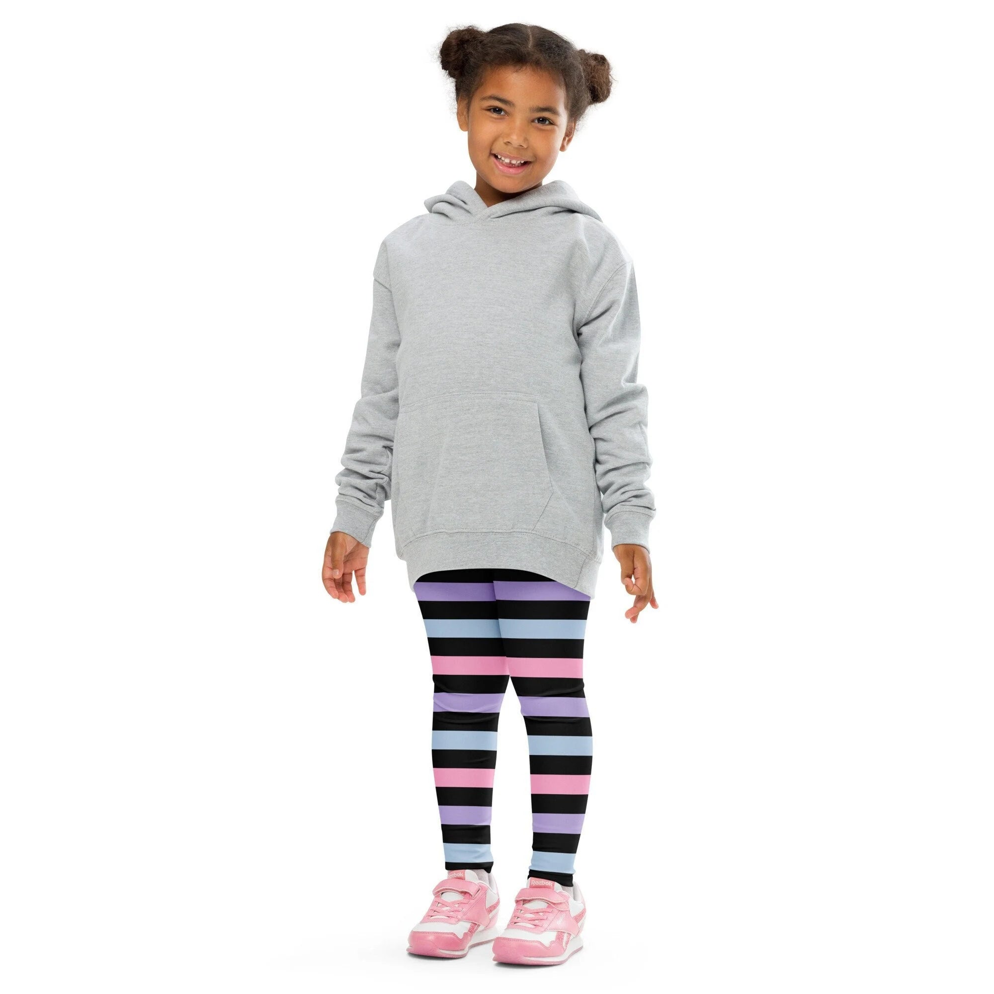 Gray hooded sweatshirt with front pocket and long sleeves paired with girls colorful striped buttery soft leggings in purple black and blue