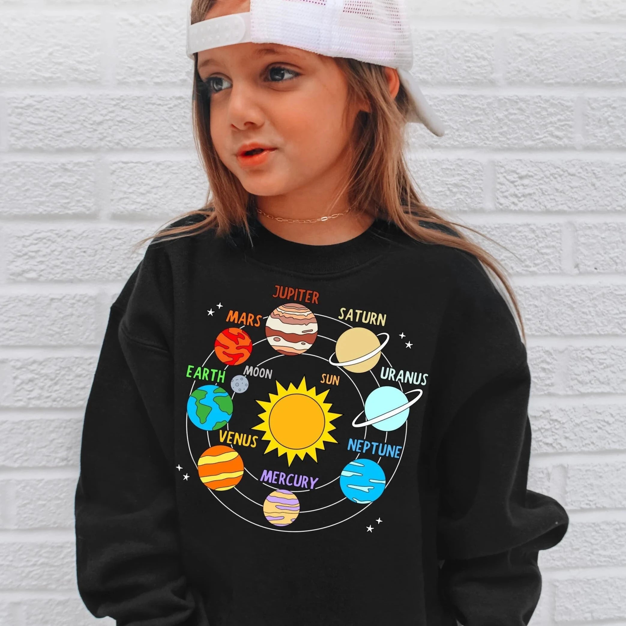 Black long-sleeved kids sweatshirt featuring a colorful solar system graphic with planets and the sun