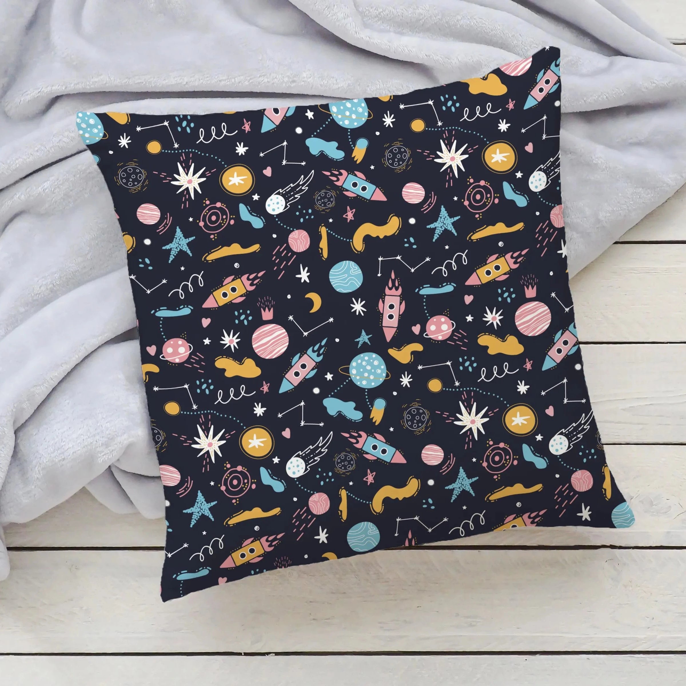 Outer space kids pillow with a playful pastel rocket and planet pattern on dark navy for bedrooms and playrooms