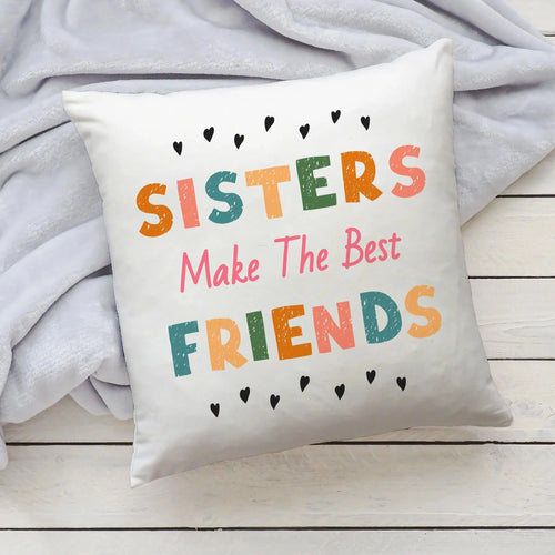 White throw pillow with colorful distressed lettering and black hearts reading sisters make the best friends