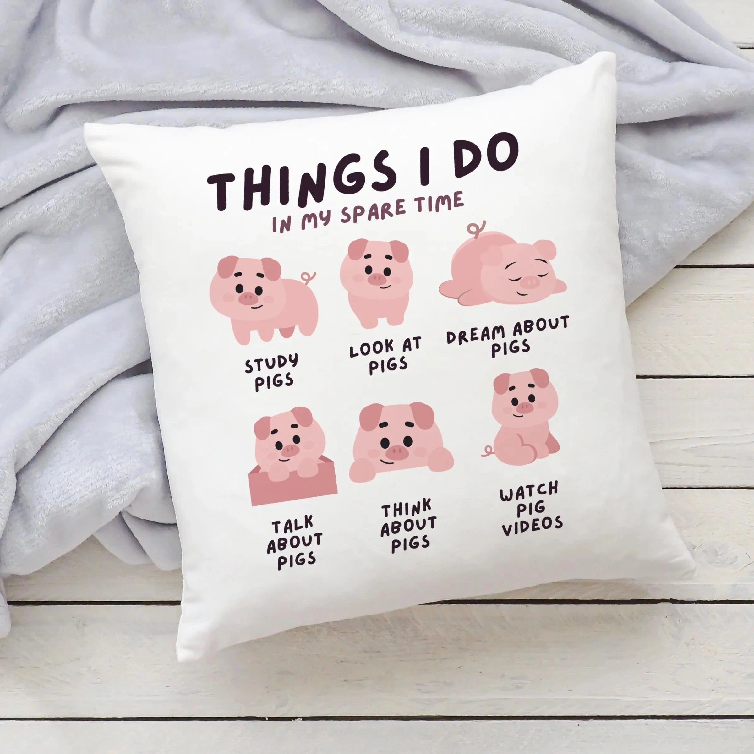 White throw pillow with playful pink cartoon pigs and text things i do in my spare time perfect for kids