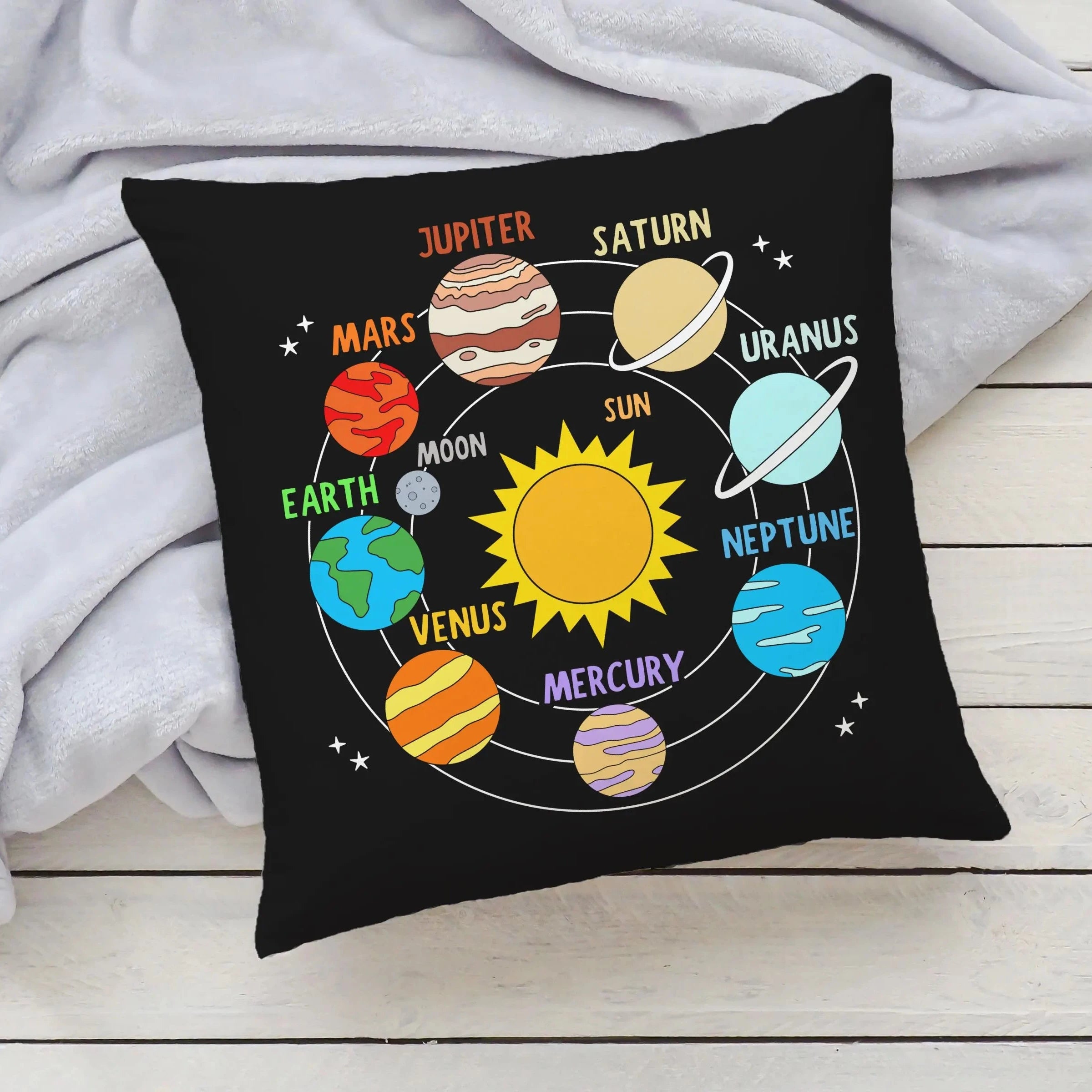 Black cushion featuring a colorful cartoon solar system illustration with labeled planets and the sun for kids learning
