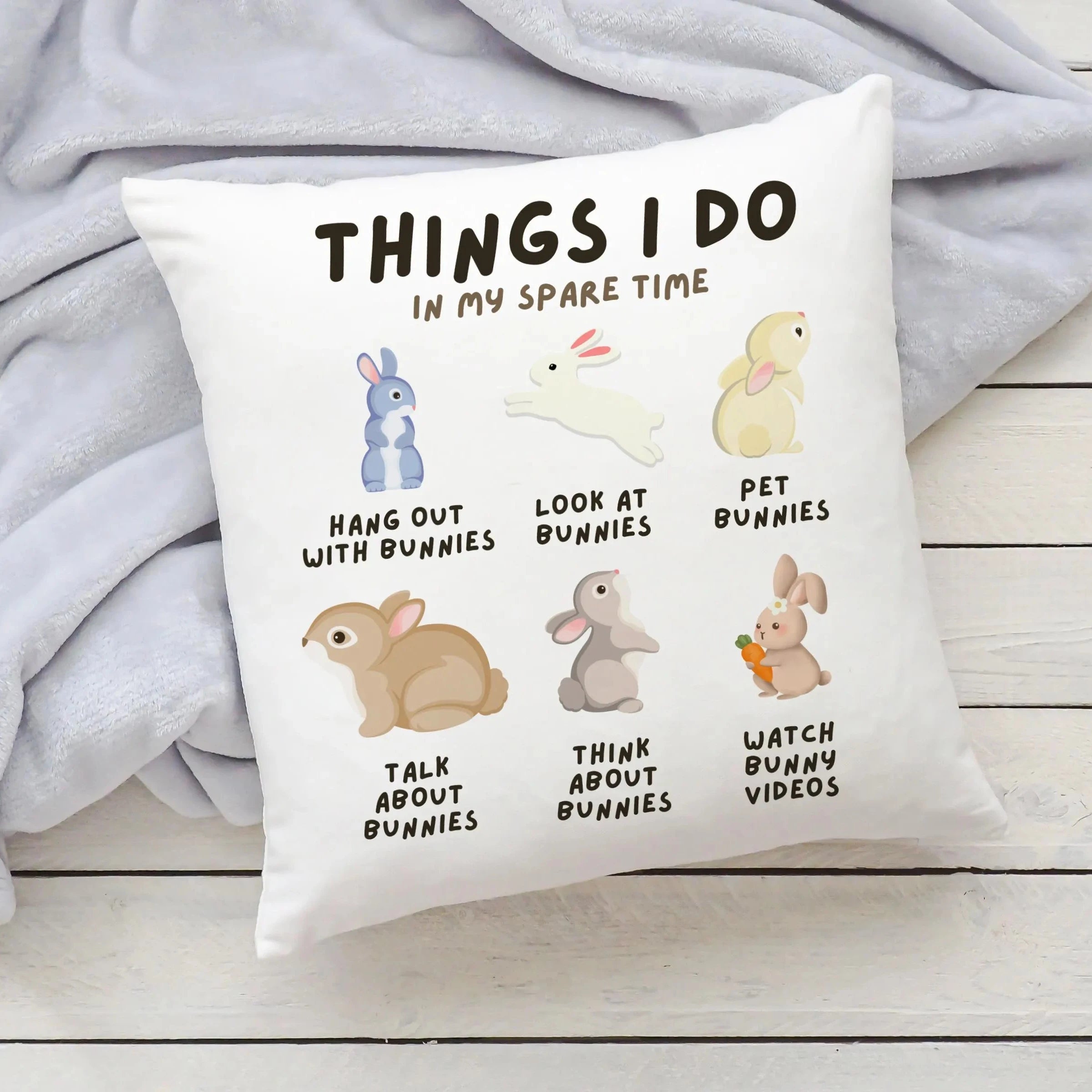 White kids throw pillow featuring playful illustrated bunnies with spare time activities text and rabbit theme