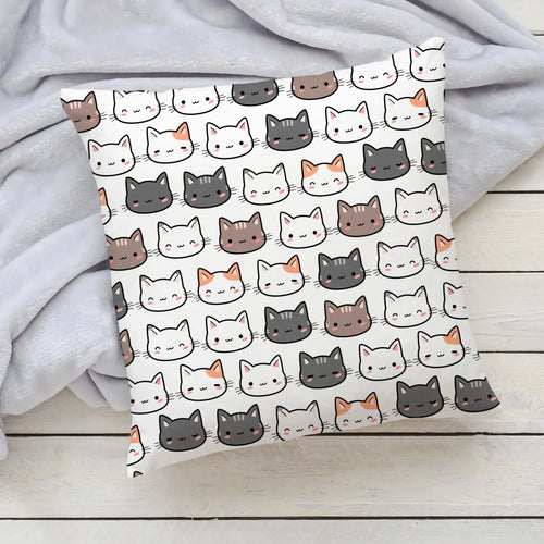 White pillow with a repeating pattern of colorful cartoon cat faces perfect for girls bedrooms nurseries and playrooms