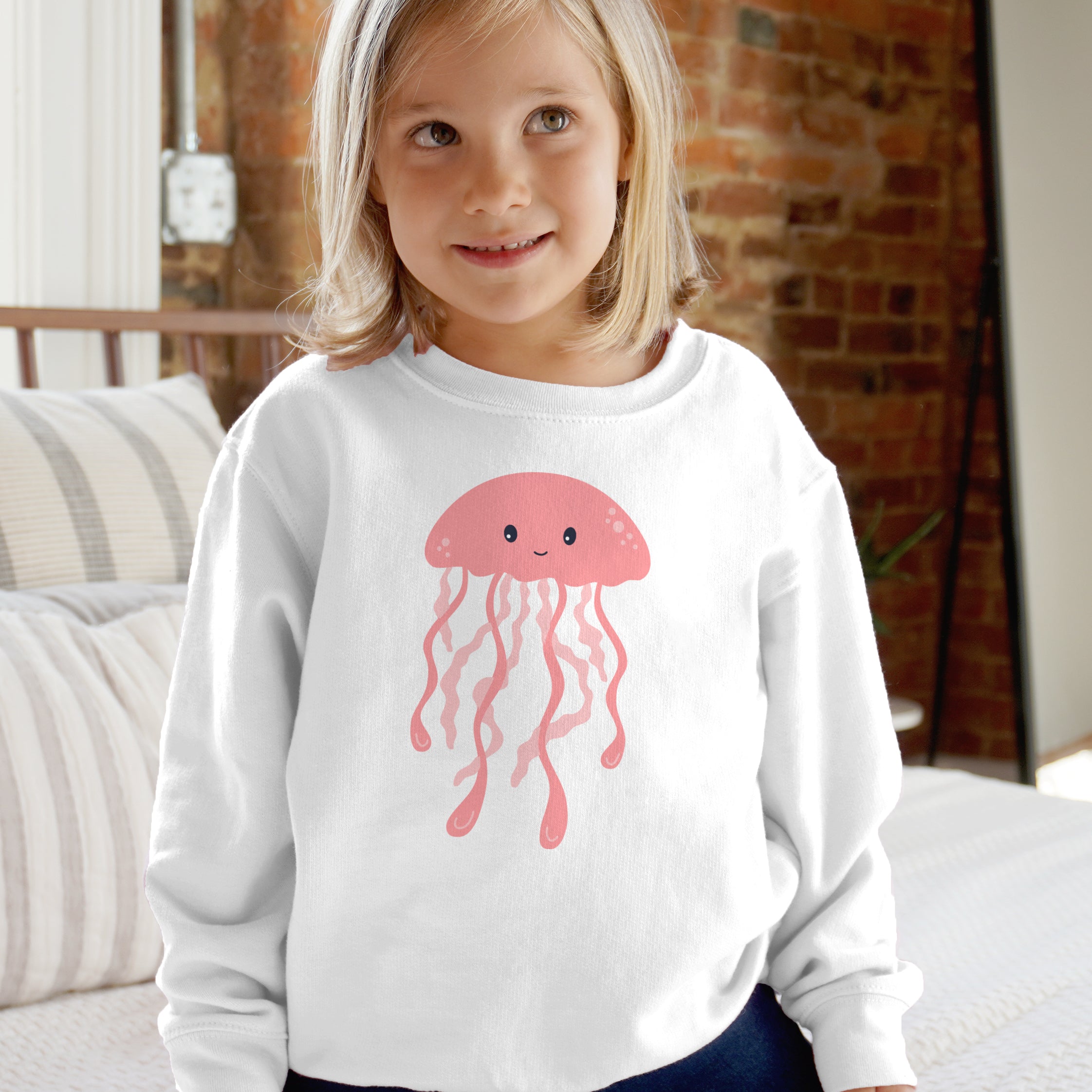 White long-sleeved kids sweatshirt with pink cartoon jellyfish graphic featuring soft cotton material