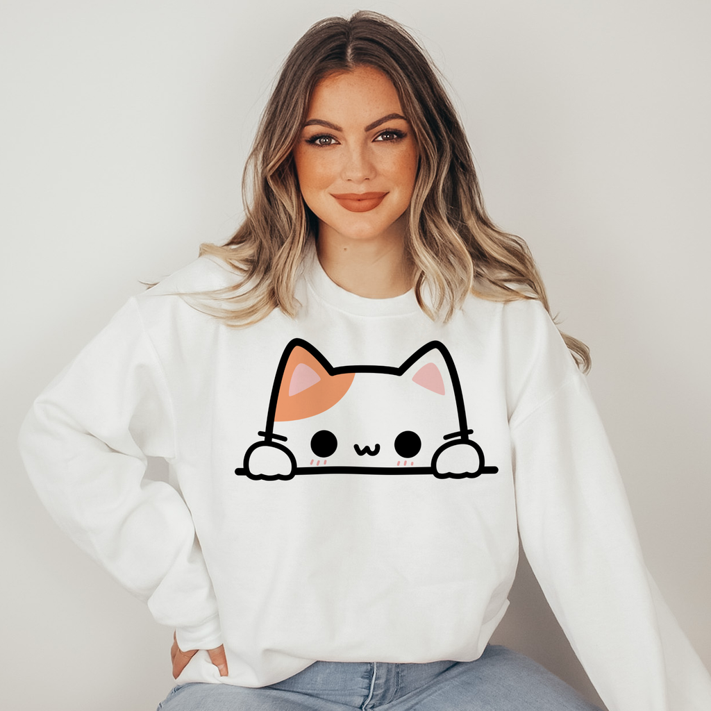 Woman wearing a white sweatshirt with a cat face design on a plain background