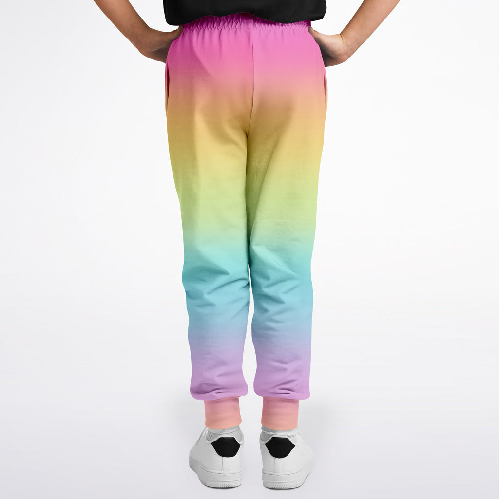 Girls bright rainbow jogger pants with soft stretchy fabric and elastic waistband in a vibrant rainbow gradient