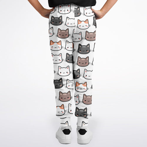 Girls cat jogger pants in white with a playful multicolor cartoon cat face pattern for casual wear