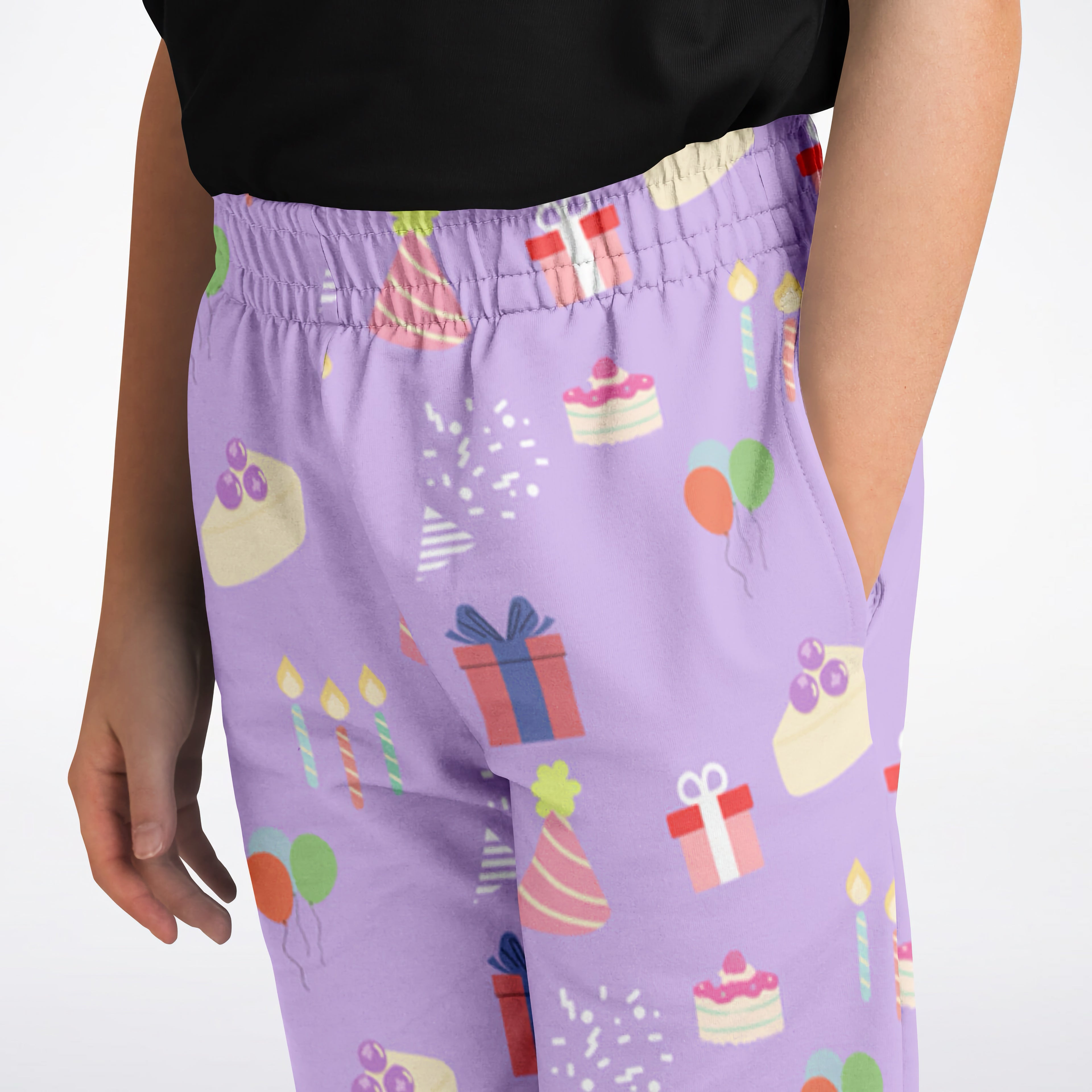 Girls birthday jogger pants in purple with a playful birthday pattern of cakes gifts balloons and candles