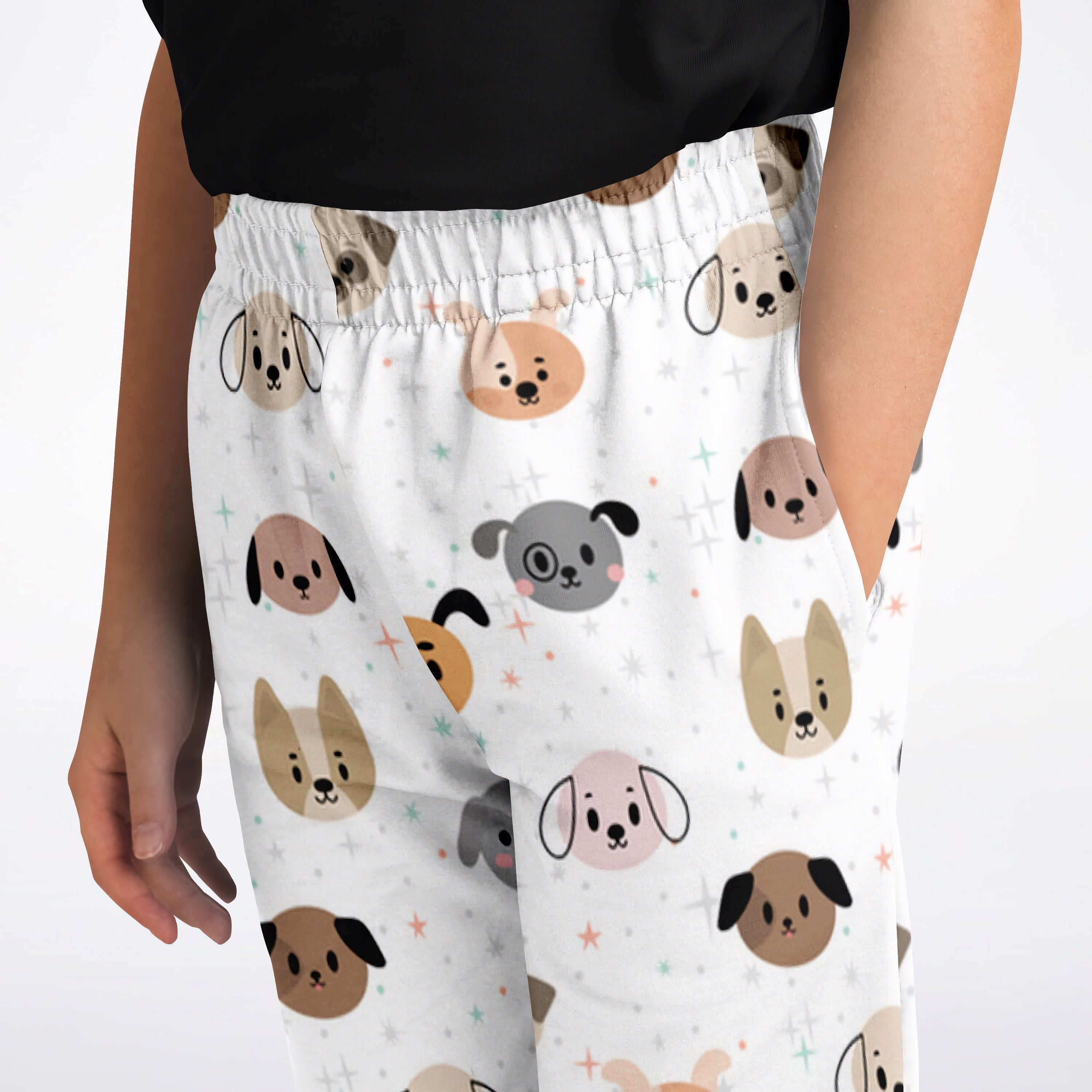 White kids dog face jogger pants featuring playful beige gray and pink cartoon dog faces pattern