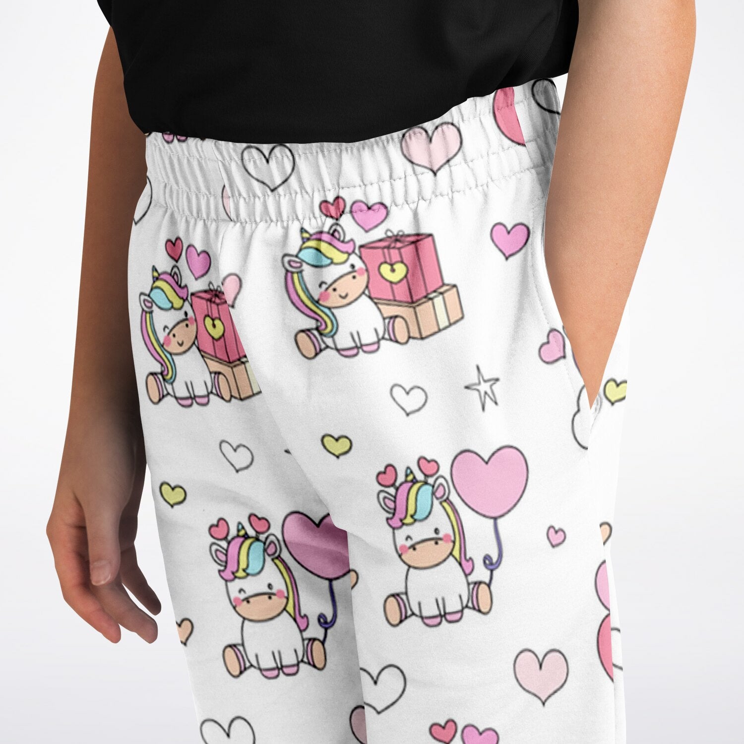 Girls unicorn birthday jogger pants in white with playful cartoon unicorns rainbow manes pink hearts and gift boxes pattern