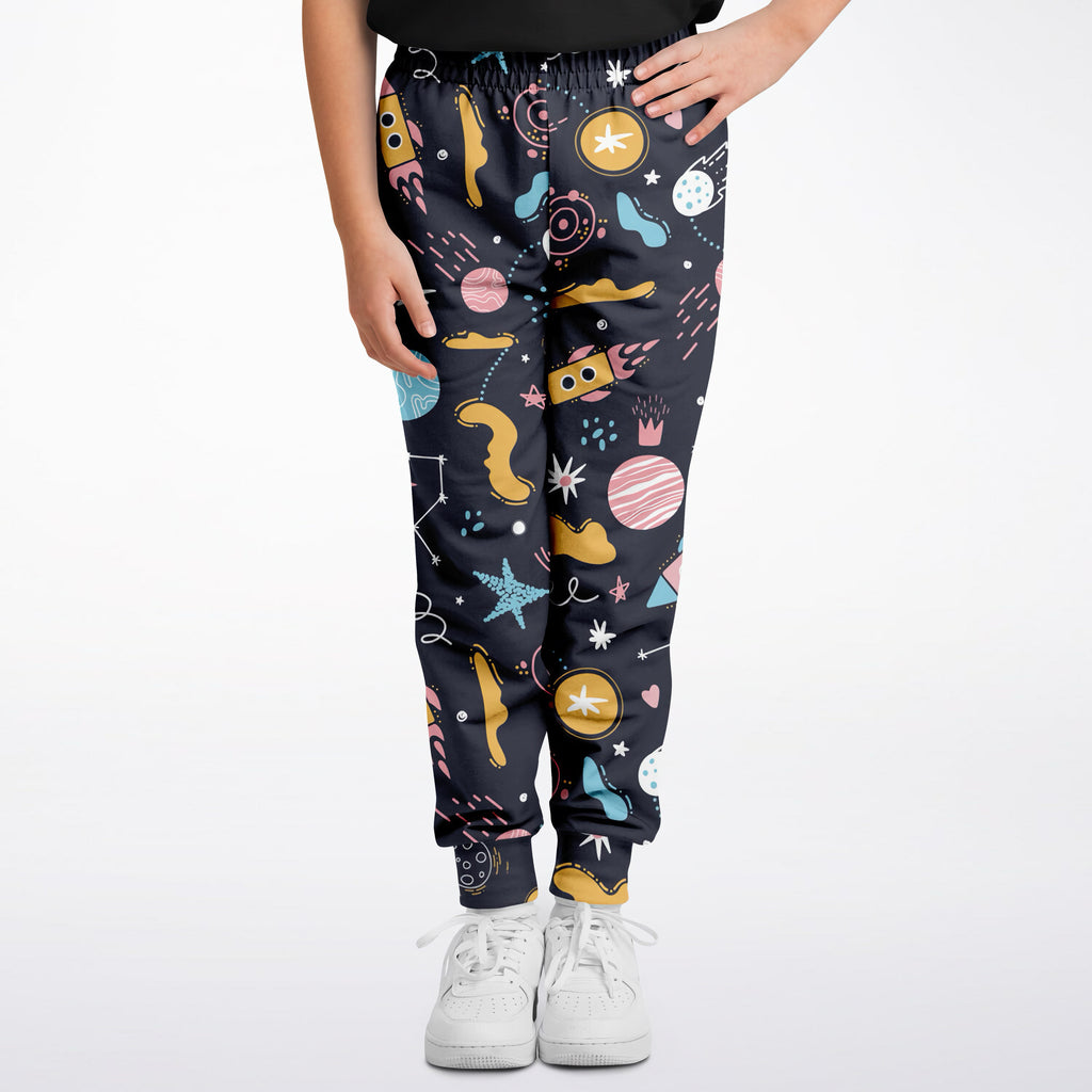 Kids outer space jogger pants in dark navy with colorful pastel planets stars rockets and geometric shapes pattern
