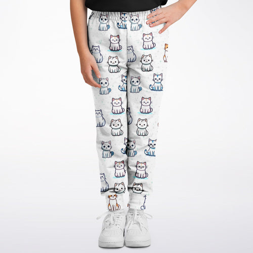 Girls cat pattern jogger pants in white with a playful multicolor cartoon cat print for casual wear