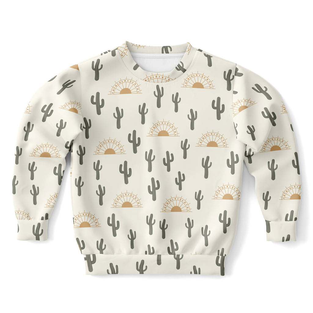 Cream-colored kids sweatshirt with repeating black cactus and tan sunburst pattern made of cozy cotton fleece