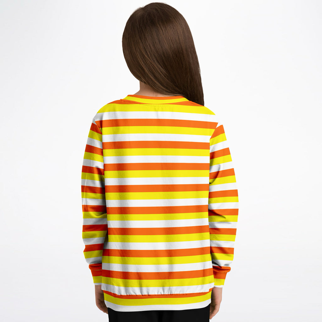 A child wearing a kids candy corn stripes halloween sweatshirt with orange yellow and white stripes in cozy cotton fleece