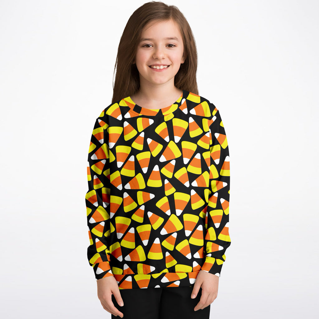 Kids candy corn halloween sweatshirt in black cotton fleece featuring vibrant orange yellow and white candy corn pattern