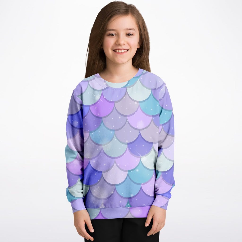 A child wearing a girls purple mermaid scales sweatshirt in cozy cotton fleece with pastel purple blue scales