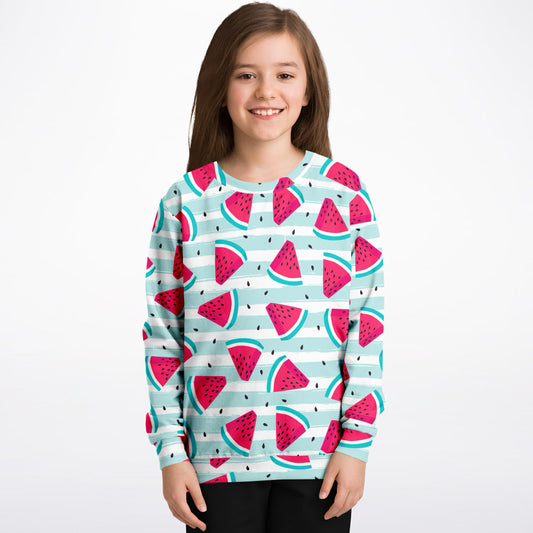 Child wearing a sweater with watermelon pattern on a white background