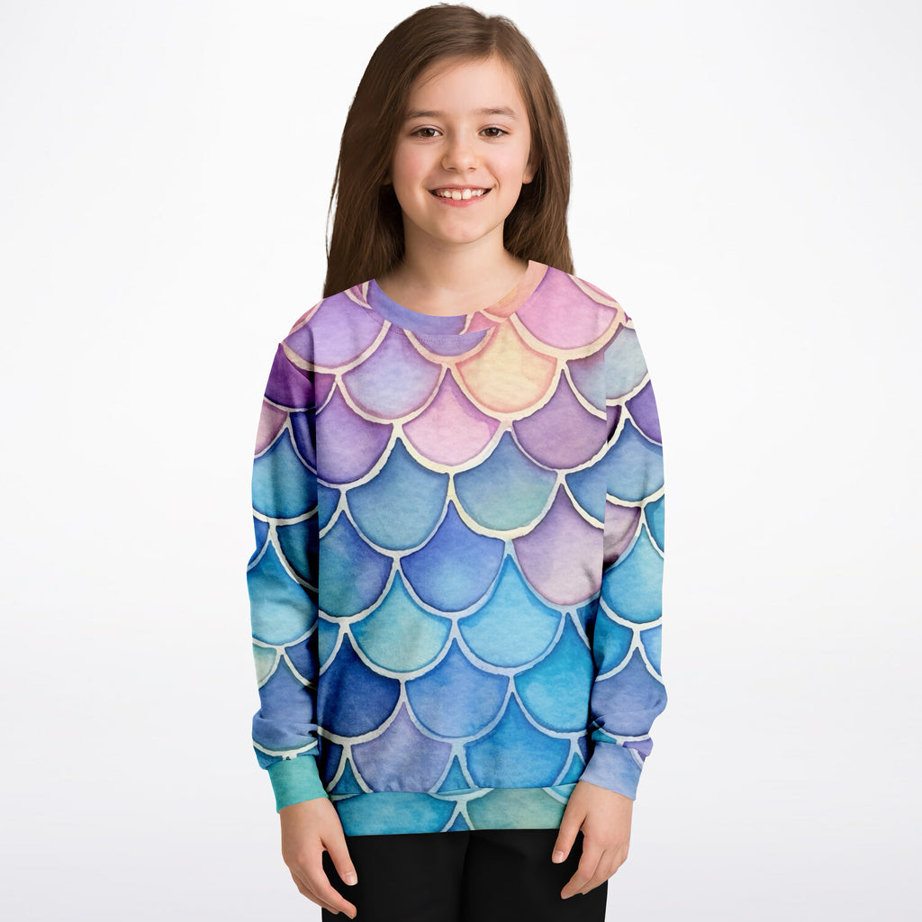 A child wearing a girls colorful mermaid scales sweatshirt with vibrant purple blue pink watercolor cotton fleece fabric